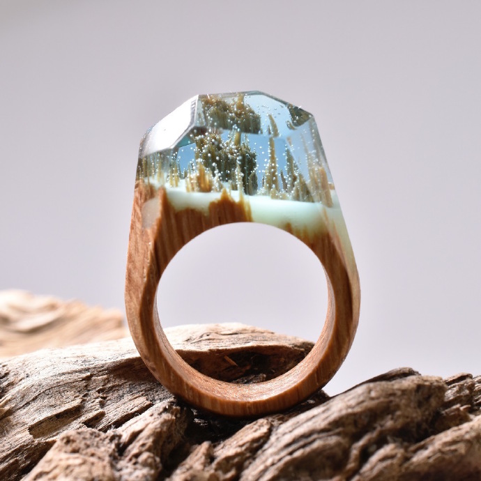 加拿大珠宝商“Secret Wood”出品的戒指，由木材、树脂和蜂蜡制作。木头的断面在树脂中形成了奇妙的微型自然景观。每个戒指里都有一个世界。。
