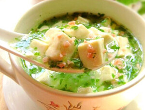 【DIY嫩滑翡翠豆腐羹】1.火腿切成末，小白菜剁碎，豆腐切小丁，用开水焯一下捞出；2.锅中倒油烧热，下葱末炝锅，倒入剁碎的小白菜略炒；3.倒入鸡汤烧开，加盐、鸡精调味，用水淀粉勾芡，待汤汁粘稠，撒入火腿末即可~~~