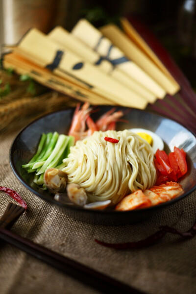 《辣白菜朝鲜冷面》干冷面准备好，然后锅上烧开水，其他材料也都一应俱全准备好，黄瓜切丝，蒜拍末，香菜切小段。水烧开，把冷面放进锅里。用筷子不停搅拌，防止粘锅和互相粘连。煮大概8分钟左右，关火。把热水倒出…