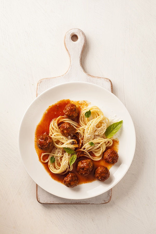 Spaghetti with meatballs with fresh basil and tomato sauce.