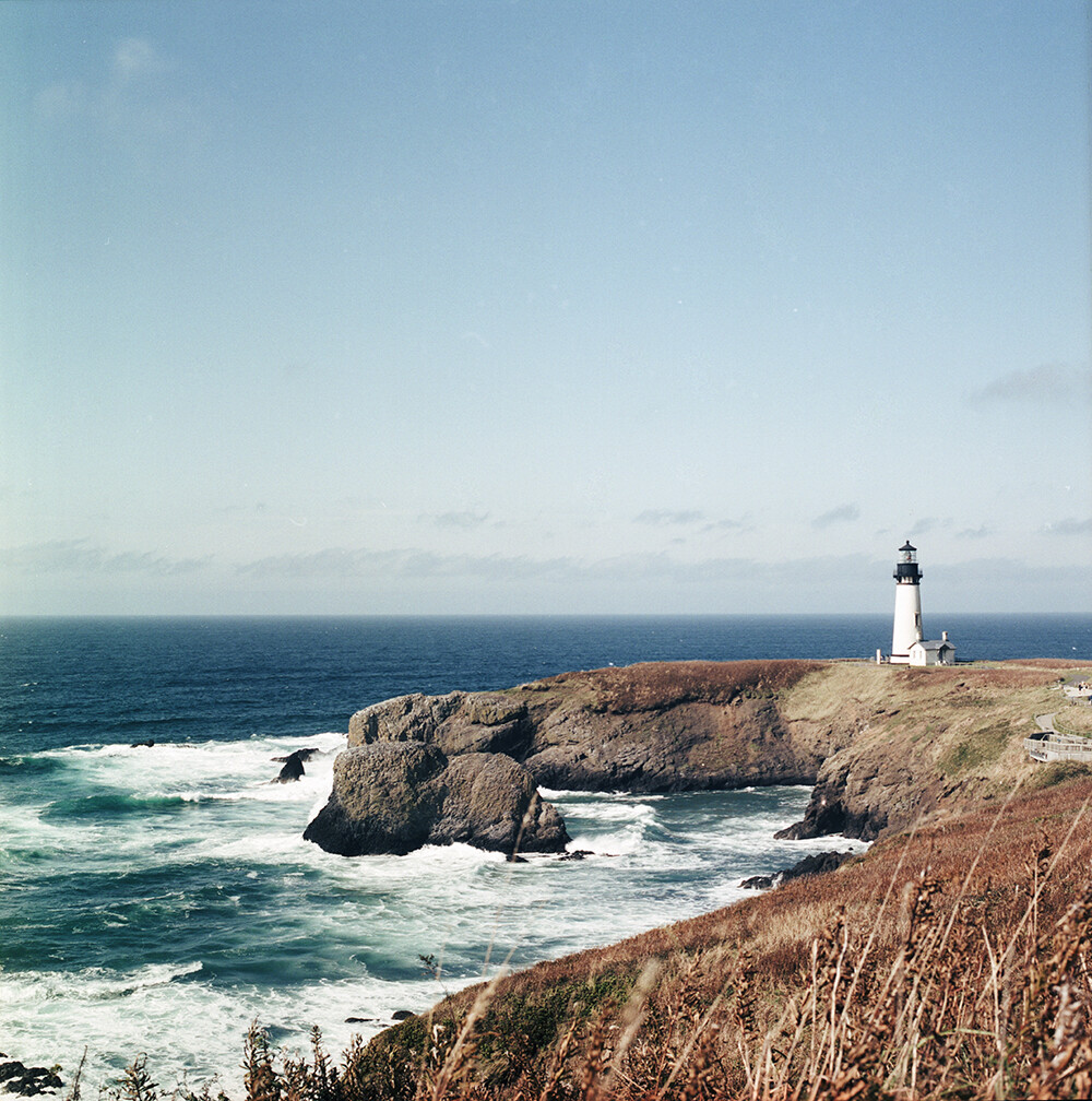 Yaquina Head Lighthouse
太平洋西北海岸那么多景点，Yaquina却有它的独特之处。这里的海滩没有细沙，取而代之的是黑色的鹅卵石。海浪拍打着堆积在岸边的小石头，撞击之间发出叮叮咚咚清脆的响声，非常特别。
Yaquina灯塔所采用的菲涅耳镜头在法国巴黎制造，1873年运抵俄勒冈后首次点亮并使用至今。规模较大的灯塔通常有一个管理员和两个助理，管理员和一级助理的家人均在此居住，二级助理则往往是个单身汉。遥想百年前，交通不发达，灯塔又往往位于距离城镇遥远的海岬处，大一点的Yaquina或有好几人在那里工作，小一点的灯塔有时仅有一两个人驻守。我难以想象经年累月独自面对太平洋的寂寞