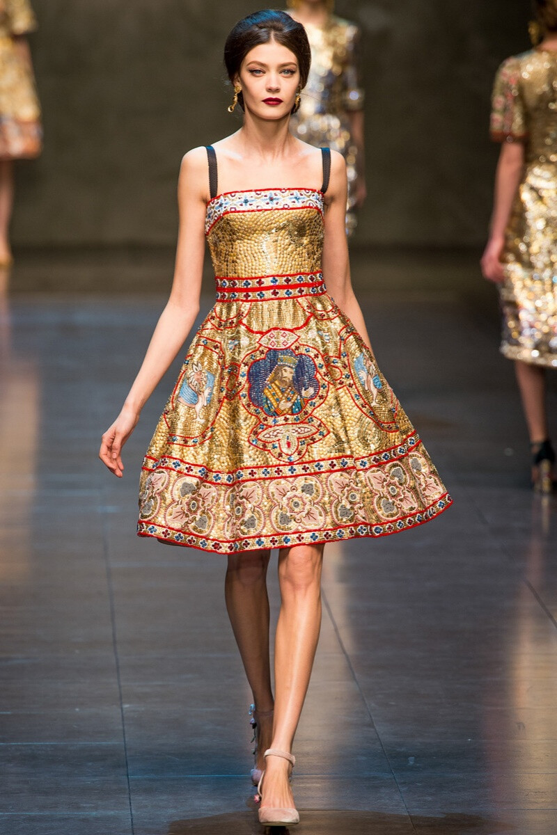 Dolce & Gabbana 2013秋冬高级成衣系列 本次秋冬季系列的灵感来源是西西里岛蒙特利尔大教堂中那些金碧辉煌的镶嵌画 黑 ，白，灰，红色的交织让整个秀缤纷异常，蕾丝和镶嵌更让每套衣服都像艺术品一样华丽绝美。金色的马赛克壁画印花、华丽如珠宝的宝石镶嵌、象征皇权又带有宗教感的皇冠，每一个LOOK都似威严的拜占庭女王般美艳不可方物～