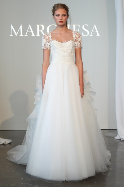 Marchesa 2015春夏系列婚纱 经典蕾丝搭配优雅如流水般的白纱裙摆，剪裁贴合新娘的身形，没有任何闪耀动人的配饰，束在上方的头纱、握在手中的花束，是让新娘更加闪闪发光的完美配角～