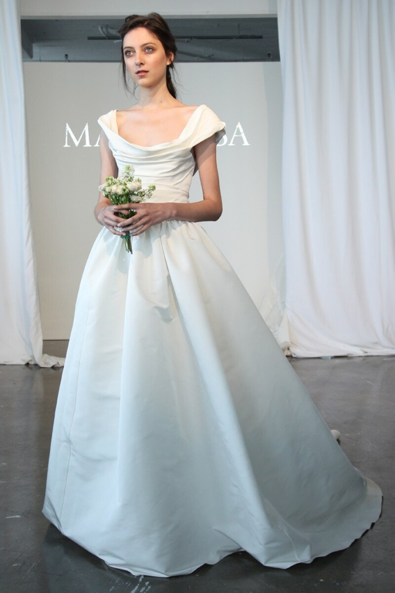 Marchesa 2015春夏系列婚纱 经典蕾丝搭配优雅如流水般的白纱裙摆，剪裁贴合新娘的身形，没有任何闪耀动人的配饰，束在上方的头纱、握在手中的花束，是让新娘更加闪闪发光的完美配角～