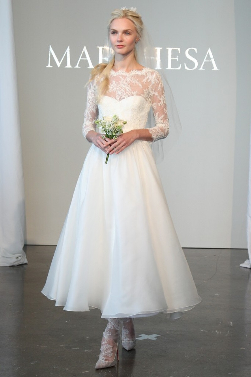 Marchesa 2015春夏系列婚纱 经典蕾丝搭配优雅如流水般的白纱裙摆，剪裁贴合新娘的身形，没有任何闪耀动人的配饰，束在上方的头纱、握在手中的花束，是让新娘更加闪闪发光的完美配角～