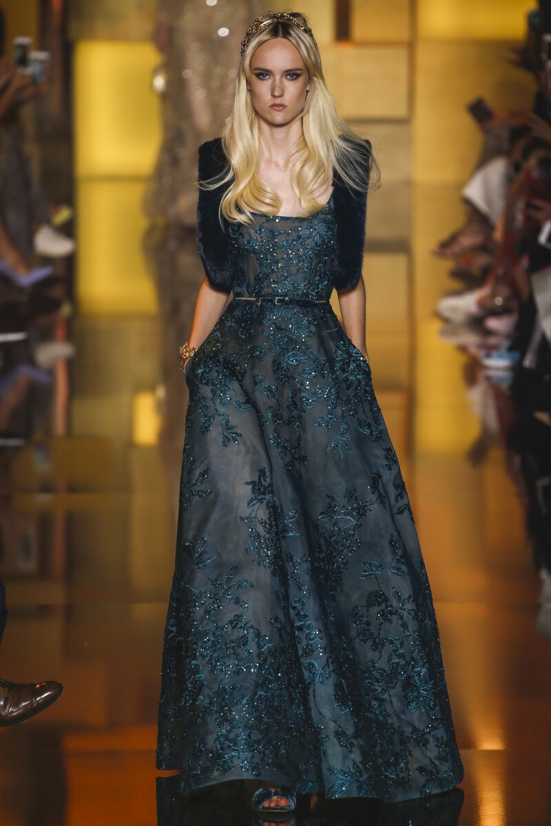 Elie Saab 2015 秋冬高级定制 Elie Saab品牌风格，一向都是以奢华高贵、优雅迷人的晚礼服而著称，宛如又一个VALENTINO。Elie Saab 的高级定制女装秀,运用丝绸闪缎、珠光面料、带有独特花纹的雪纺、银丝流苏、精细的刺绣……让女人在行走间浮游流动，充满飘逸轻灵的梦幻色彩，为所有女人构筑一个童话般的梦。同时运用褶皱、水晶和闪钻， Elie Saab 大手笔勾勒出精美奢华的服饰盛宴，挥洒着熠熠星光，带给所有人炫目时尚的同时，亦让Elie Saab的女人化身成最优美的精灵国度公主～