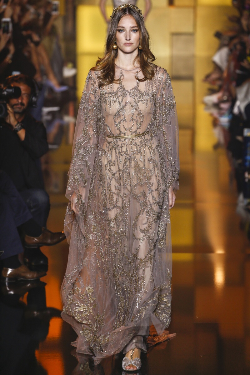 Elie Saab 2015 秋冬高级定制 Elie Saab品牌风格，一向都是以奢华高贵、优雅迷人的晚礼服而著称，宛如又一个VALENTINO。Elie Saab 的高级定制女装秀,运用丝绸闪缎、珠光面料、带有独特花纹的雪纺、银丝流苏、精细的刺绣……让女人在行走间浮游流动，充满飘逸轻灵的梦幻色彩，为所有女人构筑一个童话般的梦。同时运用褶皱、水晶和闪钻， Elie Saab 大手笔勾勒出精美奢华的服饰盛宴，挥洒着熠熠星光，带给所有人炫目时尚的同时，亦让Elie Saab的女人化身成最优美的精灵国度公主～