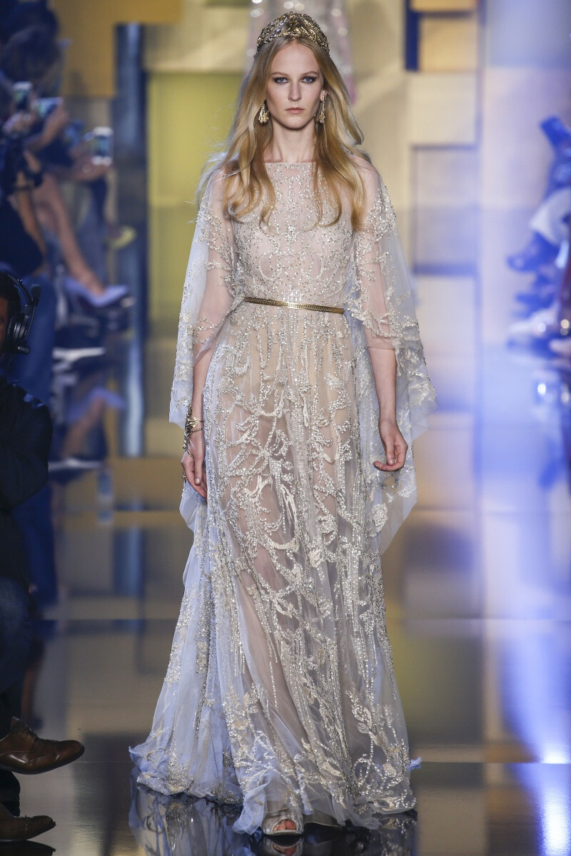 Elie Saab 2015 秋冬高级定制 Elie Saab品牌风格，一向都是以奢华高贵、优雅迷人的晚礼服而著称，宛如又一个VALENTINO。Elie Saab 的高级定制女装秀,运用丝绸闪缎、珠光面料、带有独特花纹的雪纺、银丝流苏、精细的刺绣……让女人在行走间浮游流动，充满飘逸轻灵的梦幻色彩，为所有女人构筑一个童话般的梦。同时运用褶皱、水晶和闪钻， Elie Saab 大手笔勾勒出精美奢华的服饰盛宴，挥洒着熠熠星光，带给所有人炫目时尚的同时，亦让Elie Saab的女人化身成最优美的精灵国度公主～