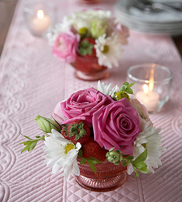 Three dessert-cup flower arrangements make low centerpieces to allow for easy table conversation. Fill cups with strawberries, then water. Push flower stems straight into strawberries for quick arrang…