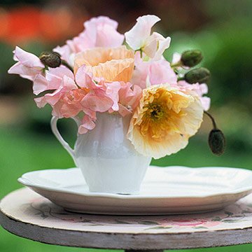 Sweet Little Wedding Centerpiece A white creamer is a perfectly elegant alternative to a regular vase. Fill it with pink sweet peas and yellow poppies. Want poppies to last longer? Cut them from the p…