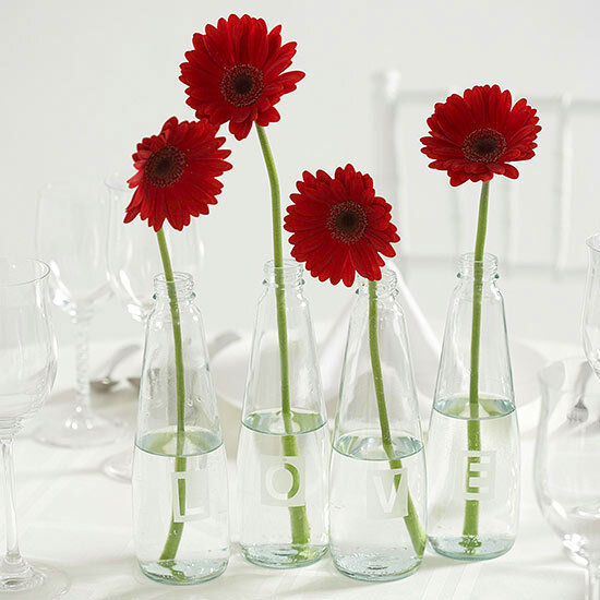 Etched-Glass Vase Centerpiece Share a message with wedding guests by etching letters onto glass vases. Try L-O-V-E, shown here, or use the bride and groom's initials for a personal touch. To make: Align scrapbooking letters across the bottles, then mark off a rectangle around each letter using maski