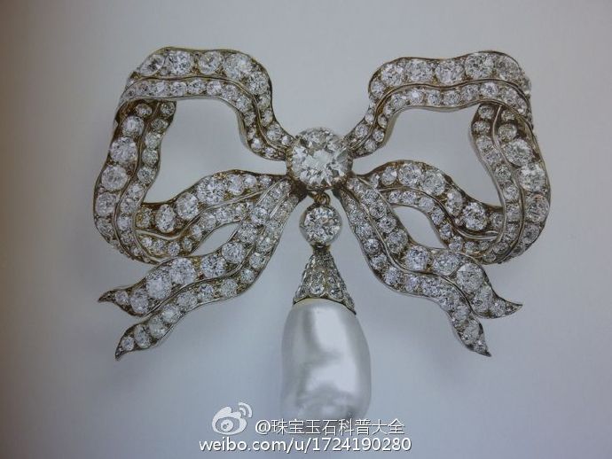 又一个女王真爱的胸针，名字叫做肯辛顿蝴蝶结胸针（The Kensington Bow brooch）下面那颗巨大的珍珠可以拆卸，那颗绝对是无核的野生海水珍珠！！！这枚胸针是1893玛丽皇后收到的结婚礼物，伊丽莎白女王在1953年继承这枚胸针后就经常佩戴，伊丽莎白皇太后葬礼上女王佩戴的也是这枚。