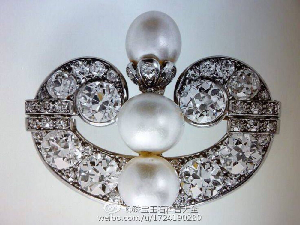 这枚胸针的名字叫做格林威尔书卷胸针（ The Greville Scroll Brooch）卡地亚在1929年设计并制作了这枚胸针，1942年Ronnie Greville女士送给了伊丽莎白皇太后，伊丽莎白女王继承后经常佩戴出席各种活动。