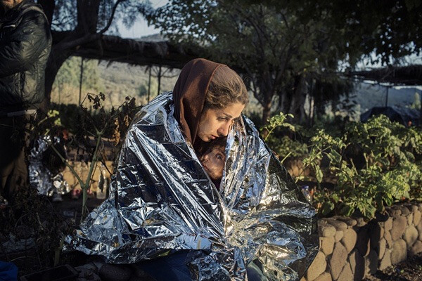 摄影师Alessandro Penso，2015年10月18日拍摄于希腊。一名难民母亲和孩子裹在急救毯中，她们刚从海上登陆 …