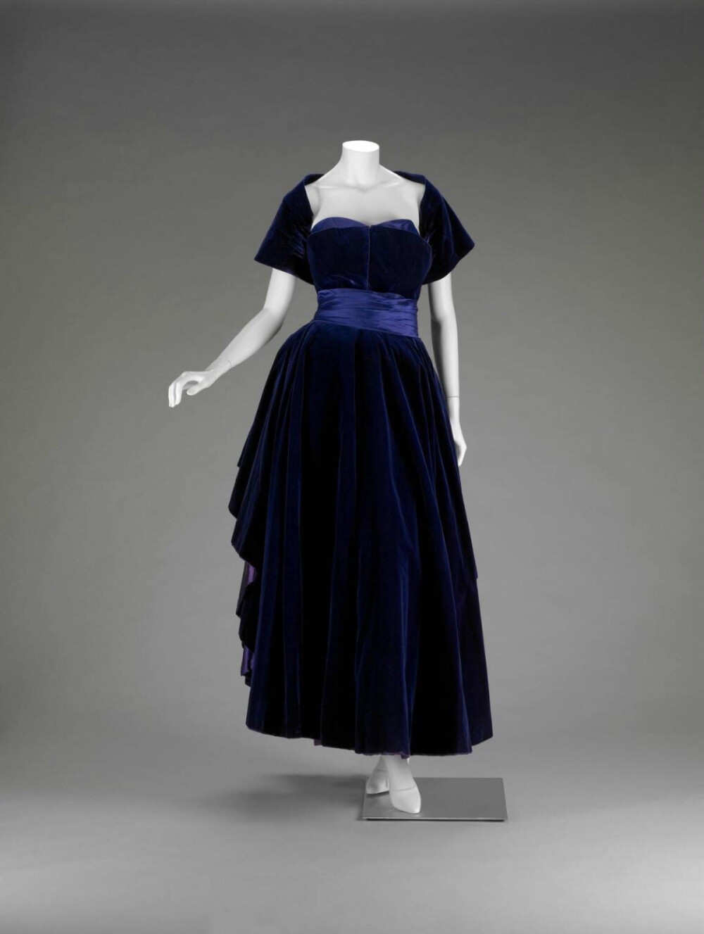 迪奥晚装，1948，布料的色泽质感对比好迷人，裙子前后两片花瓣一样的深蓝天鹅绒垂褶交叠，露出里面紫色缎子的设计手法真是巧妙~~~