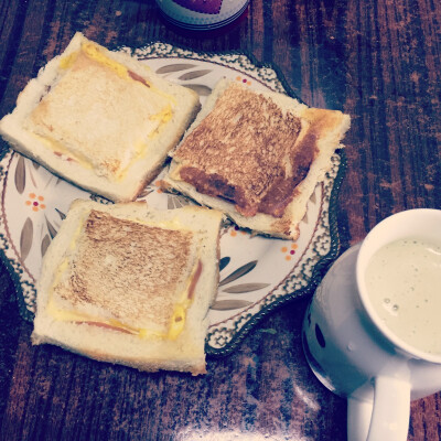 今日早餐：吐司片切边挖空黄油煎，鸡蛋打进去，放一片火腿，加一片奶酪，挖出来的吐司片盖上，翻面再微煎。再打了牛油果奶昔。