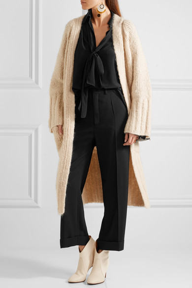 Chloé 这条阔腿裤精裁自黑色绉纱，带有压痕和卷边裤脚，腰带袢和口袋的细节设计也是精益求精，是上班出勤或出席活动的完美之选。建议搭配女衫和踝靴，并将上衣束入阔腿裤里。