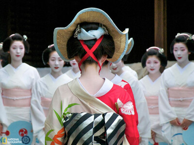 祇园祭（Gion Matsuri）是日本最古老也最着名的庆典之一。庆典中，城内有些神社的艺伎（geisha）和舞伎（maiko）会出来表演传统舞蹈。这张照片中，表演完毕而离开舞台的舞伎正与艺伎彼此问候。（摄影：Benoit Hardy-…