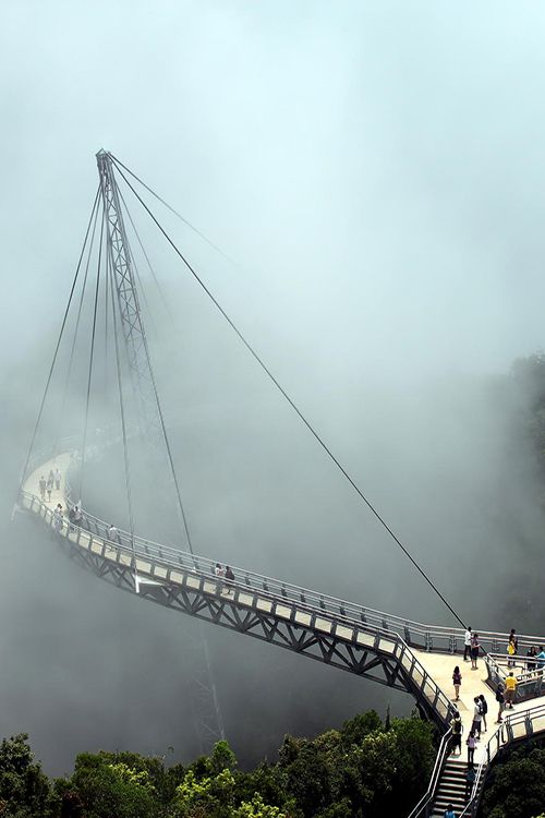 Langkawi Sky Bridge,Malaysia。兰卡威天空之桥位于马来西亚兰卡威群岛，总长125米，桥形呈圆弧状，主体由钢材料构成。特别让人觉得惊讶的是，这么个又大又重的“钢架”居然只用了一根支柱来支撑，支柱高87米，被固定在山腰，然后再由8根钢缆牵引，整个桥就这样最终被“吊”在了海拔687米的高空，连接着两个山头。 这座桥因为离地面极高，而且又窄，所以要想穿过它，需要极大的勇气的胆识。