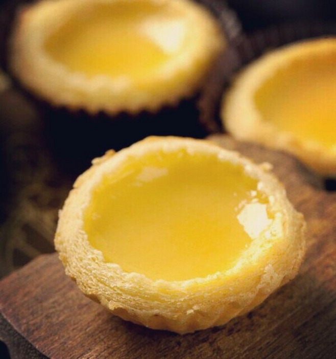  【菠萝蛋挞】 用料：蛋挞皮9个、鸡蛋黄2个、菠萝1个、低筋面粉10克、淡奶油140克、牛奶110克、白糖30克 做法：1.将淡奶油、牛奶、白糖放在小锅里，小火加热，边加热边搅拌，至白糖溶化离火，放凉，低粉过筛 2.加入蛋黄拌匀，用筛子将蛋挞水过滤，将蛋挞皮放烤盘里，放菠萝块，一个挞皮里面放4-5块菠萝即可; 过滤好的蛋挞水倒入挞皮中，烤箱220度20分钟。