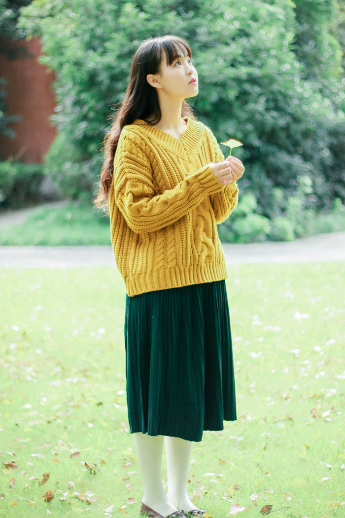 加厚款V领毛衣，宽大慵懒的版型，暖暖的姜黄色调，搭配的是复古墨绿色针织百褶半身裙。