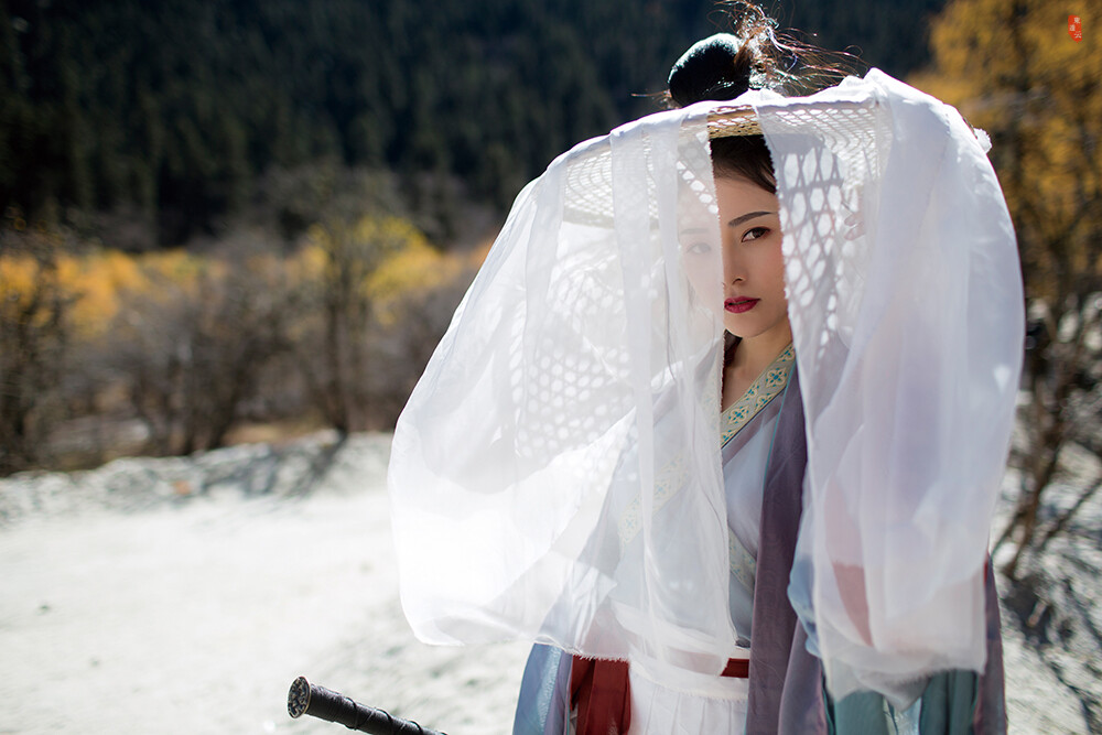 【汉服摄影' 东边云】〔 千山雪 〕 .
碧海倒如青鉴挂，潮声两岸飞白沙。沧海回头不见岸，一痕剑影扫烟霞。