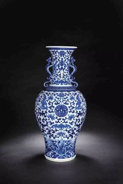 清乾隆 青花纏枝蓮雙螭耳瓶
H 49.4 cm，此瓶口沿微撇，束頸，頸飾雙螭龍耳，圓肩，腹部漸收，圈足外撇，器形壯碩。通體以青花裝飾，自上而下分繪福壽紋、貫套花卉、纏枝蓮紋，如意雲頭紋等紋飾，層次豐富清晰，頸部…