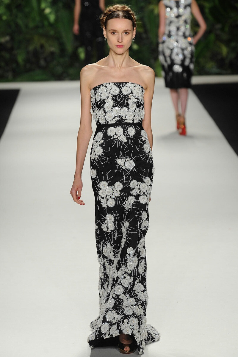 Naeem Khan 2014 春夏高级成衣 Khan这一季的灵感来源于所有与拉丁有关的元素，包括Frida Kahlo（墨西哥国宝级画家）家乡的风景、弗拉门戈舞者、墨西哥教堂、摩尔人（非洲西北部阿拉伯人与柏柏尔人的混血后代）等。模特们头顶Kahlo标志性的一字发辫（没有一字眉），连衣裙随着朱红色玫瑰花的图案垂摆。设计中有一部分借鉴了明显的西班牙风格廓型—诸如刺绣装饰的乔其纱村姑衫和喇叭裙；还有一些典型的Khan式廓型～