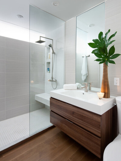 Example of a minimalist doorless shower design in Toronto with an integrated sink, flat-panel cabinets, dark wood cabinets and gray tile