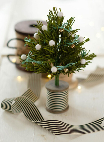 迷你可爱的小圣诞树，直接将缩小版的圣诞松树装饰在桌面上，逼真的松针是由厚皱纹纸制作而成，简单易做，是装饰圣诞节日不可或缺的小饰品。
