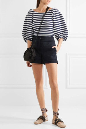 Sonia Rykiel 这款布满午夜蓝色和白色条纹的上衣，以时髦摩登的手法全新演绎了经典法式条纹和航海风设计。单品采用柔软的棉质混纺面料裁制出贴身廓形，略带褶饰的肩部和袖口收束出俏皮可爱的夸张泡泡袖，洋溢着少女般的青春朝气。不妨搭配迷你半身裙或利落短裤，以平衡单品蓬松的廓形。