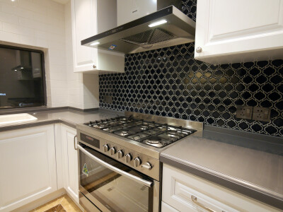 白色橱柜与白色的瓷砖，再加上电器、集成灶台、烤箱、洗碗机组成了一个颇具现代感的厨房。在集成灶台前的黑色瓷砖，也是十分的显心机，形状特别而耐脏。