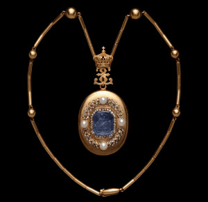 拿破仑三世时期的珍宝，欧仁妮皇后的项链和坠盒，内有欧仁妮皇后照片一张。主体部分约1860年，蓝宝石浮雕约1805年。盒子顶的E代表Eugenie，皇冠是拿破仑帝国皇冠。（欧仁妮是拿破仑三世的皇后。）钻石镶嵌成了月桂叶。浮雕做得很精细啊，拿琴的缪斯清清楚楚。原型很可能是拿破仑三世的母亲,这件吊坠盒，被皇后赠与了Burgoyne夫人，以感谢她在1870年法兰西第二帝国覆灭后，帮助皇后从法国逃亡到英格兰。这是当时皇后身上唯一一件值钱的东西