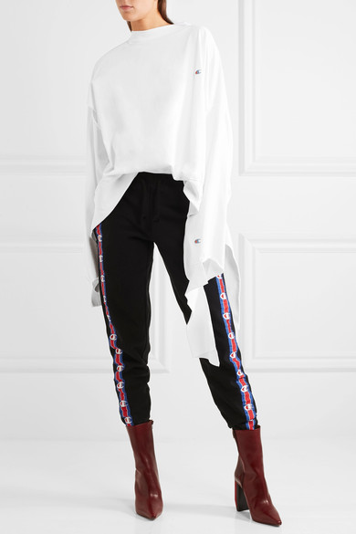 Vetements 设计双星 Demna 和 Guram Gvasalia 向一些品牌伸出橄榄枝，将其品牌中的最具代表的元素融入了 2017 春夏系列的作品中，碰撞出惊人的创意花火。系列中这款白色上衣以运动品牌 Champion 的醒目标志为主打元素，采用柔软的纯棉平纹针织面料制成，呈现出慵懒闲适的超大廓形。单品还配有挖剪式双袖，和条状拖尾边饰，…