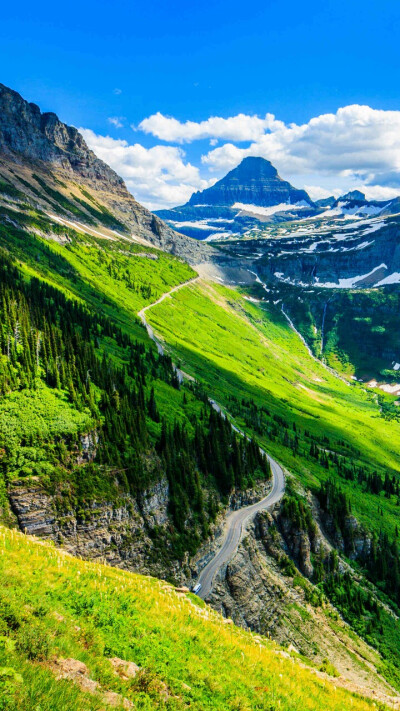 绿意盎然的山间，风景辽阔壮观，山间公路蜿蜒着，像是山的丝带，承载着行程与远方。