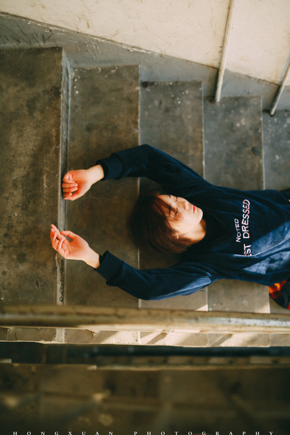 你是我的室友
摄影：洪小漩
出镜：羽希
过年在家，这是一个落寞的春节。我推掉了一些朋友的邀约，在家看日剧，或者陪妈妈寻山访寺，上香祈福。
今年回家发现全面禁烟花爆竹。我看看面目全非却被被赞颂的村庄，心下波澜不惊。这不是我长大的地方，而除夕夜少了鞭炮的轰鸣，也无非是让我更加坚信这一点。
初一那天， 恰好是羽希阳历生日，我给她发了个红包，稍稍聊了几句，新年问候。
年前最后一周的周末，我在社区楼道给她拍的照，因为不知道要写点什么文字，这才修完了却一直没腾出手来发布。
这个姑娘和我做室友也有两年了，我们一起经历了两轮涨房租，一起养了一只叫可乖的猫，一起换了热水器洗衣机，一起粉刷了墙壁。我为护她被一个男人指着鼻子破口大骂，胳膊上让人掐出淤青三周不褪，她为我冲上去直接和人扭打，架势就像一只疯狂的小牛。
我们一起过了一段互相搀扶的日子，那些时日，两个人走路都要左顾右盼，周遭弥漫着不安。
记得有一天，她搂着我泣不成声，哭着说抱歉。不擅长安慰人的我，僵硬地拍着她的后背，说没关系，说我一直在。
后来，从一场糟糕的感情泥沼中得以脱身的好姑娘，遇到了另一个心仪的男生。这个男生在工作日早上为她盛粥煎鸡蛋，周末陪