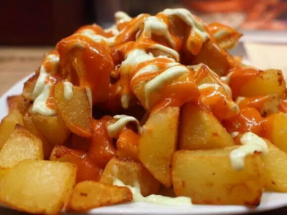 辣味番茄酱拌炸土豆块（Patatas bravas）
西班牙人真的是非常的爱喝酒，啤酒、红酒、香槟等等。而这道辣味番茄酱拌炸土豆块（Patatas bravas）其实是一道前菜，也是下酒菜。
如果你走在西班牙的街头突然有些饿了，又没有到饭点儿的时候，不妨点一道Patatas bravas，来解解馋。