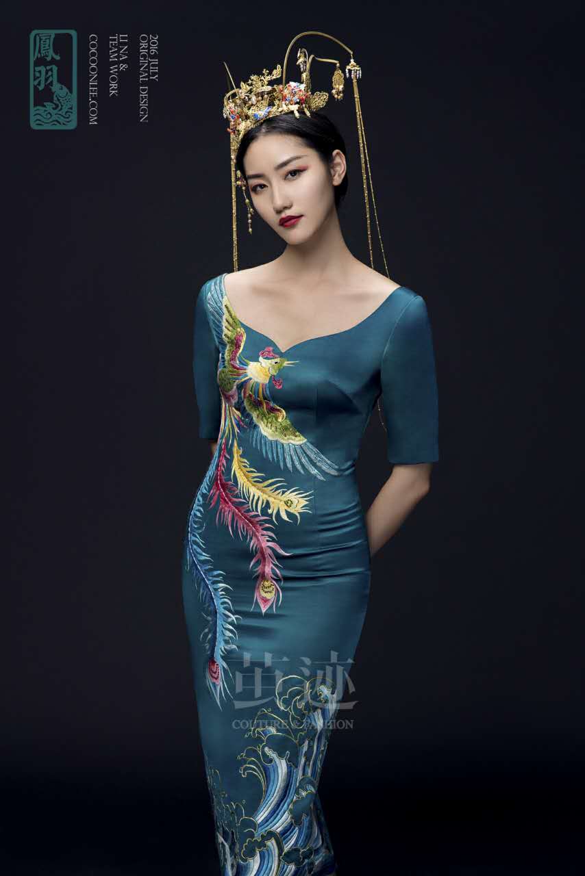此款凤羽以宝石绿真丝库缎作为主面料，以鸡心领口设计，来展现女性性感妩媚，领下至腰间以彩色手绣凤凰为主，展翅的凤凰壮丽高贵，设计灵巧且鲜活，凤翅与凤身、凤尾处均有贴钻点缀，凤凰尾部与礼服下摆处的海浪交相呼应，苍浪以金边勾形，蓝白色的海浪既显古典又磅礴大气。凤凰自古就有祥和、恬淡的美感，并象征着光明的未来和富贵与吉祥，而此款凤凰的五彩光华，更是表达完满与幸福的美好祝愿。