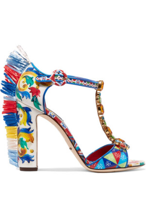 Dolce & Gabbana 这款 “Bianca” 漆皮凉鞋精彩地捕捉了 2017 春夏系列的愉悦气息。它印有品牌独特的三原色 “Carretto” 图案——灵感来自西西里岛的热情文化；T 字带则缀满熠熠生辉的珠宝铆钉。粗鞋跟上毛绒绒的酒椰叶纤维边饰更是惊喜着墨，令人眼前一亮。