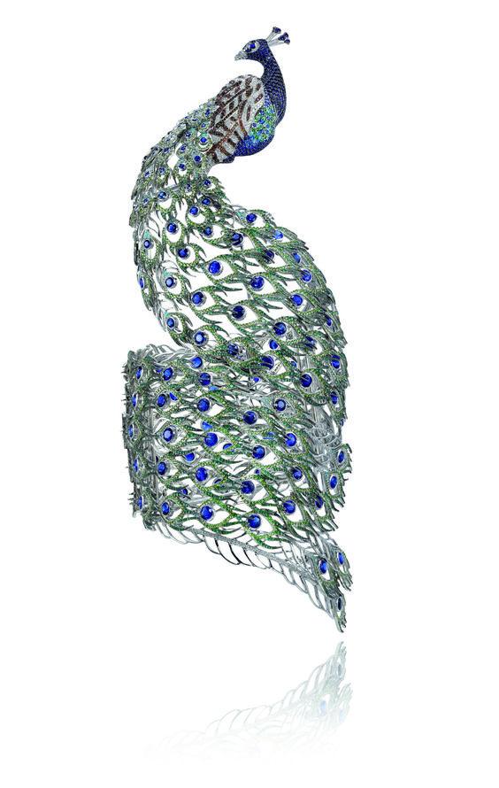 萧邦孔雀造型手镯
这枚萧邦孔雀手镯，由精美的孔雀尾巴如蕾丝花边般轻盈环绕着手腕，里面还有个小秘密，就是手镯上有50根细密的羽毛的锁扣做到完全隐藏，这些羽毛由 7500 枚微小的直径均在0.5 毫米的珍稀宝石构成，可见珠宝工匠人的心思是如此细腻。

