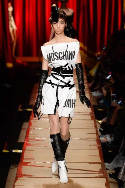 Moschino 2017 秋冬高级成衣 本季系列设计师使用了日常生活中弃之不用的商品包装元素，纸箱上的运输符号、缠绕的封箱胶带、不同面料表现的包装纸以及混乱感拼接的广告图案，充满态度与趣味～