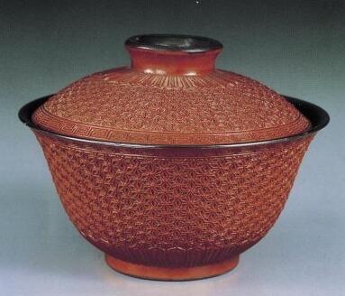 乾隆皇帝的御用茶具
仿雕漆珊瑚红釉银里盖碗，碗及盖内外均包银，外壁于素胎时雕刻成仿雕漆绣球纹锦地纹饰，口沿雕回纹一周，足边莲瓣纹，施透明釉烧成后，再挂珊瑚红釉，二次低温烧成。碗底白瓷地上矾红书“大清乾隆年制”六字三行篆款