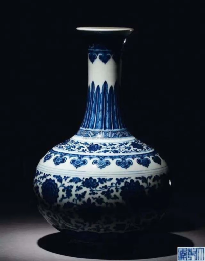 （清）乾隆 青花缠枝莲纹赏瓶
说明：瓶口外撇圆唇，朿长颈斜肩，扁球腹，平底缩胫，假圈足外凸。通体施白釉釉色中泛青，颈上端饰青花海浪纹，下方及肩部饰云肩纹。肩上方与腹壁饰缠枝莲纹，颈下方有青花蕉叶承不…