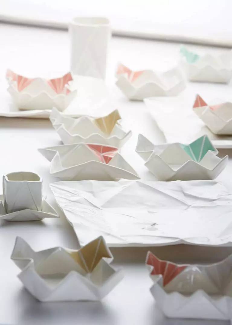 【折纸餐具】Angelina Erhorn是来自汉堡的一位很好的陶瓷餐具创意人。她总能把握流行的喜好。近来，折纸艺术正成为时尚，她以此为灵感给碗碟杯盏设计了全新的形态：这些有趣的瓷器似乎变得皱皱巴巴，如同一张张展开的折纸一般。
