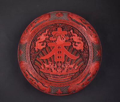 清乾隆 剔彩壽春八寶開光文仕雅集寶盒
W 30.6 cm H 11.5 cm 雕工果斷遒勁，刀法精准有力，是乾隆年間仿製嘉靖雕漆的代表作品。然而此盒造型特徵與明代作品風格已明顯不同，且漆質更佳，色澤鮮亮，雕工精湛，已為嘉…