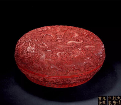 清乾隆 剔紅海水紋九龍捧盒
D 35.4cm 此拍品為一圓形大捧盒，平蓋面，弧壁，子母口扣合，圈足。體態碩大，表面堆厚朱漆，盒內部及足內均髹黑漆。捧盒正面雕刻五龍翔雲戲珠圖，下部外壁雕祥雲巨龍四隻，合共九隻，故…