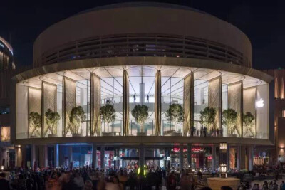 
Foster + Partners设计的迪拜苹果商店里，以Filigreed碳纤维折叠百叶窗，该百叶窗白天遮蔽店体以及外面的阳光，晚上开放时可以观赏到哈利法塔。