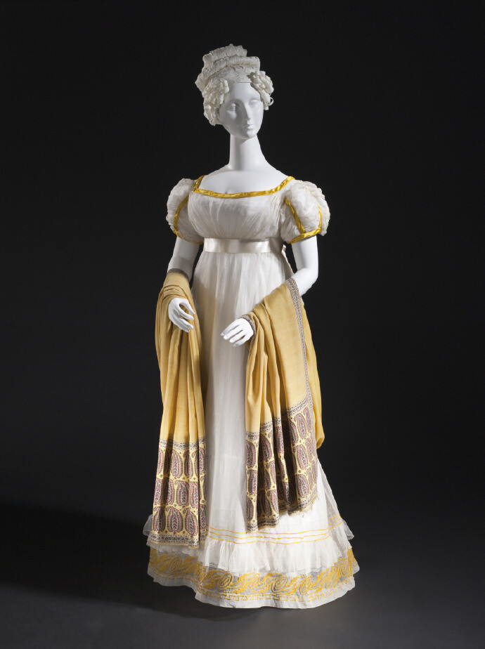 1820年的一件法国女装，帝政款，轻薄的白色棉纱，亮金色缎带镶边，裙摆上是与镶边同色的羊毛刺绣花纹。 ​​​​