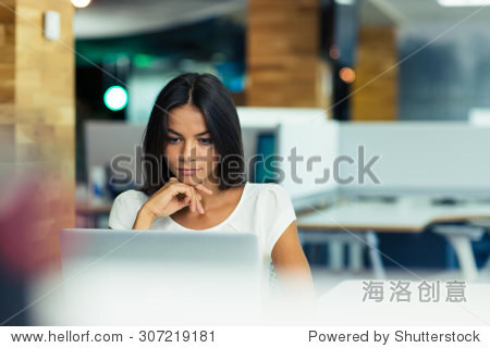 Portrait of a serious businesswoman using laptop in office