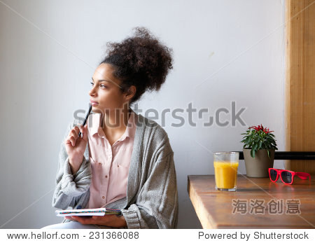 Portrait of a young woman sitting at home with pen and paper